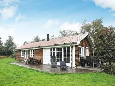 a small house with a deck and chairs on it at 8 person holiday home in Fjerritslev-By Traum in Torup Strand