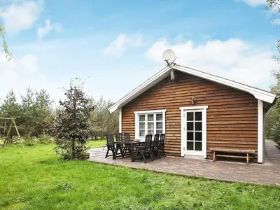 a cabin with a table and chairs on a deck at 8 person holiday home in Fjerritslev-By Traum in Torup Strand