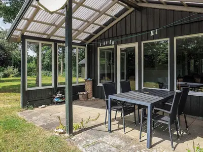 a patio with a table and chairs under a pergola at 2 person holiday home in Thyholm-By Traum in Thyholm