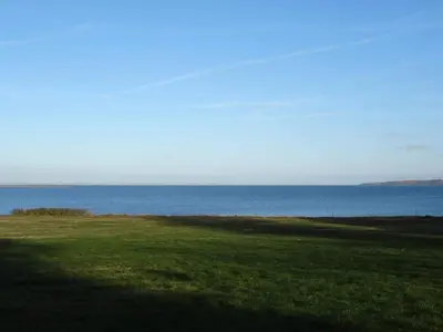 a field of grass with the ocean in the background at 5 person holiday home in Roslev-By Traum in Sønder Thise