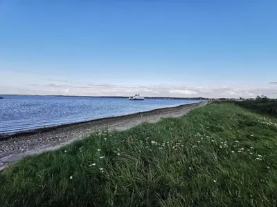 a beach with a boat in the water at 5 person holiday home in Roslev-By Traum in Sønder Thise