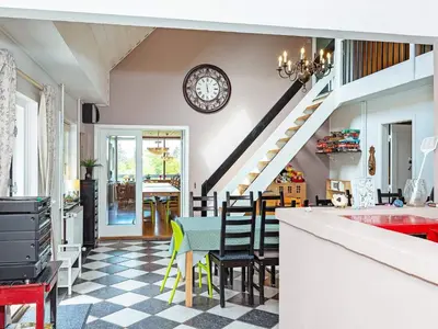 a kitchen with a table and a clock on the wall at 19 person holiday home in Løgstør-By Traum in Trend