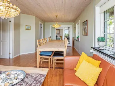 a dining room with a table and a couch at 19 person holiday home in Løgstør-By Traum in Trend