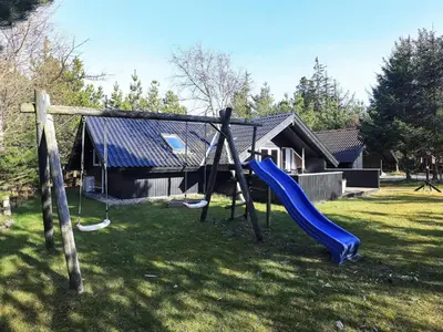 a playground with a slide in front of a house at 6 person holiday home in Saltum-By Traum in Saltum