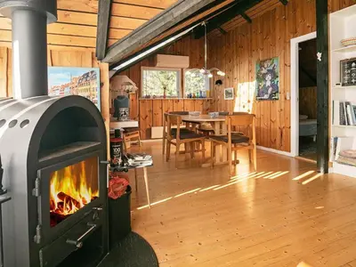 a living room with a fireplace and a dining room at 6 person holiday home in Saltum-By Traum in Saltum