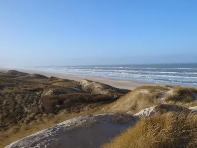 a beach with rocks and the ocean in the background at Bright Beach House Retreat - By Traum Ferienwohnungen in Trudslev