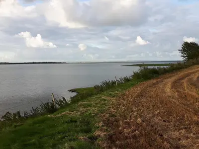 a dirt road next to a large body of water at 9 person holiday home in Hurup Thy-By Traum in Sindrup