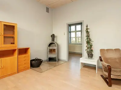 a living room with a wood stove in the corner at 26 person holiday home in Roslev-By Traum in Åsted