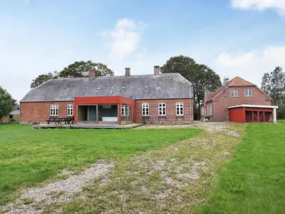 a large red brick house with a large yard at 26 person holiday home in Roslev-By Traum in Åsted