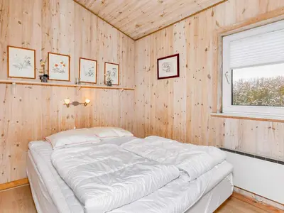 a bedroom with a bed in a wooden wall at 6 person holiday home in Vestervig-By Traum in Vestervig