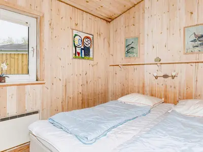 a bedroom with a bed in a wooden wall at 6 person holiday home in Vestervig-By Traum in Vestervig