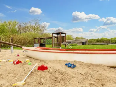 a boat sitting in the sand in a playground at 6 person holiday home in Vestervig-By Traum in Vestervig