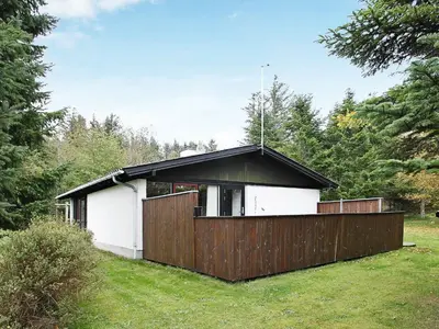 a small white house with a wooden fence at 6 person holiday home in Saltum-By Traum in Saltum
