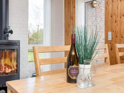 a bottle of wine sitting on a table with a fireplace at 7 person holiday home in Struer-By Traum in Humlum