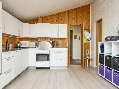 a kitchen with white cabinets and wooden walls at 7 person holiday home in Struer-By Traum in Humlum
