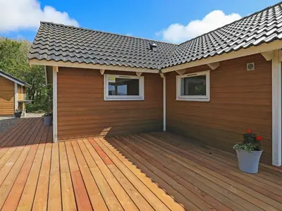a house with a wooden deck in front of it at 6 person holiday home in Vestervig-By Traum in Vestervig