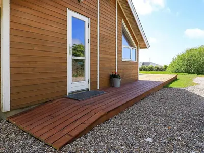 a wooden deck on the side of a house at 6 person holiday home in Vestervig-By Traum in Vestervig