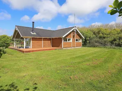 a wooden house with a large grassy yard at 6 person holiday home in Vestervig-By Traum in Vestervig
