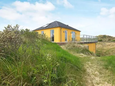 a yellow house on the top of a hill at Luxury Seaside Retreat - By Traum Ferienwohnungen in Tranum Strand