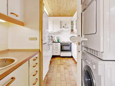 a kitchen with white cabinets and a washer and dryer at Luxury Retreat with Pool - By Traum Ferienwohnungen in Hvalpsund