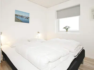 a white bed in a white bedroom with a window at Luxury Spa Retreat by Sea in Vrist