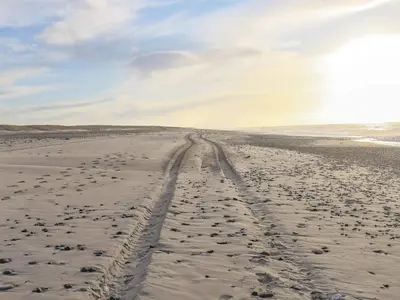 a sandy beach with tire tracks in the sand at Luxury Spa Retreat by Sea in Vrist