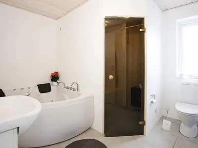 a bathroom with a tub and a sink and a toilet at Luxury Spa Retreat by Sea in Vrist