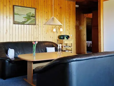 a living room with a table and a leather couch at Seaside Retreat with Sauna - By Traum Ferienwohnungen in Vrist