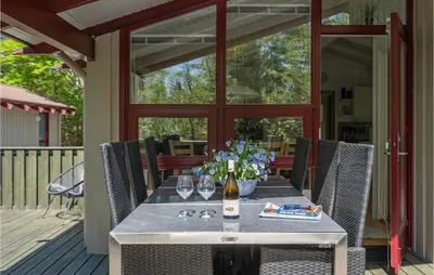 a table with wine glasses and flowers on a deck at Holiday Home Saltum Doggerbanke in Saltum