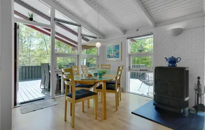 a dining room with a table and a wood stove at Holiday Home Saltum Doggerbanke in Saltum