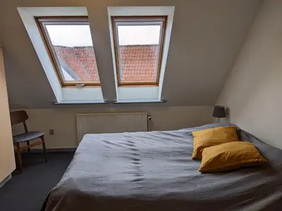 a bedroom with a large bed with two windows at Sevel Kro in Vinderup