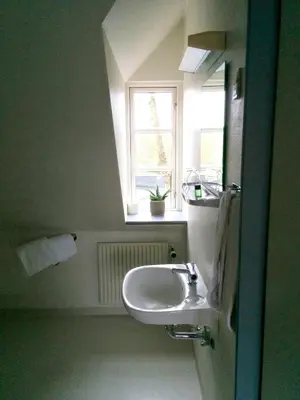 a bathroom with a sink and a window at Sevel Kro in Vinderup