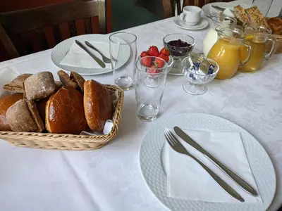 a table with plates and a basket of bread on it at Sevel Kro in Vinderup