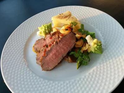 a plate of food with meat and vegetables on a table at Sevel Kro in Vinderup