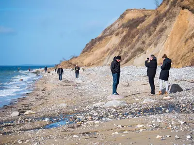 a group of people taking pictures of the beach at Næsbydale Badehotel in Ranum