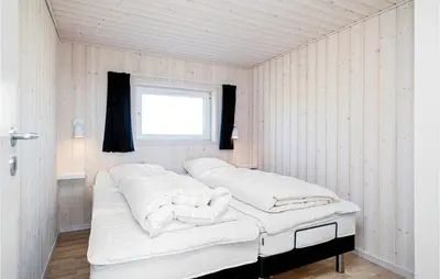 a bedroom with two beds in a room with a window at Studio Holiday Home In Lokken in Løkken
