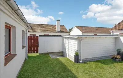 a backyard with a white fence and a garage at Two-Bedroom Holiday Home In Pandrup in Pandrup