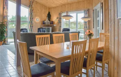 a dining room with a wooden table and chairs at Four-Bedroom Holiday Home In Thisted in Thisted