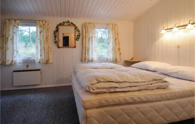 a bedroom with two beds and a mirror and windows at Two-Bedroom Holiday Home In Thisted in Thisted
