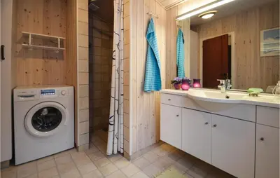 a bathroom with a washing machine and a sink at Two-Bedroom Holiday Home In Thisted in Thisted
