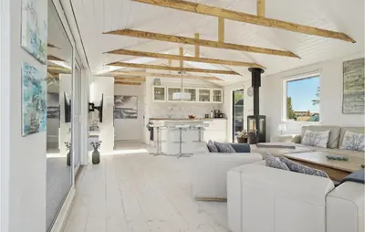 a living room with white furniture and a kitchen at Three-Bedroom Holiday Home In Thisted in Nørre Vorupør