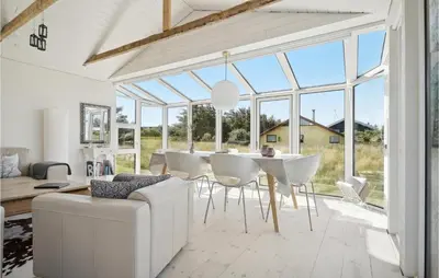 a dining room with white furniture and large windows at Three-Bedroom Holiday Home In Thisted in Nørre Vorupør