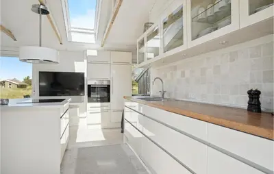 a kitchen with white cabinets and a large window at Three-Bedroom Holiday Home In Thisted in Nørre Vorupør