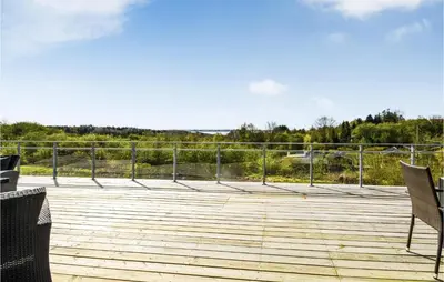 a deck with two chairs and a fence at Three-Bedroom Holiday Home In Spottrup in Spottrup
