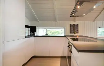 a kitchen with white cabinets and a counter top at Four-Bedroom Holiday Home In Spottrup in Spottrup