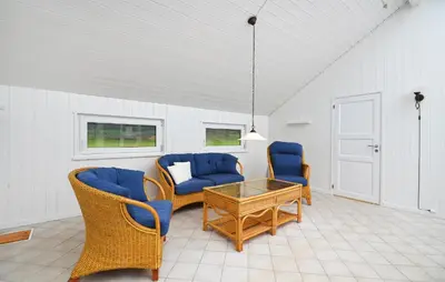 a living room with blue chairs and a table at Four-Bedroom Holiday Home In Spottrup in Spottrup
