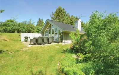 a small house in a field with a yard at Four-Bedroom Holiday Home In Spottrup in Spottrup