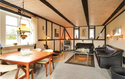 a living room with a wooden ceiling and a table at Three-Bedroom Holiday Home In Spottrup in Spottrup