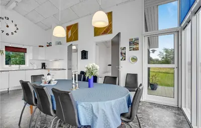 a kitchen and dining room with a table and chairs at Three-Bedroom Holiday Home In Skals in Skals