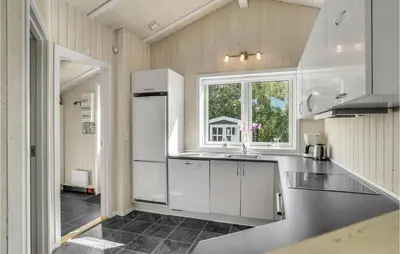 a kitchen with white cabinets and a sink and a window at Two-Bedroom Holiday Home In Logstor in Løgstør